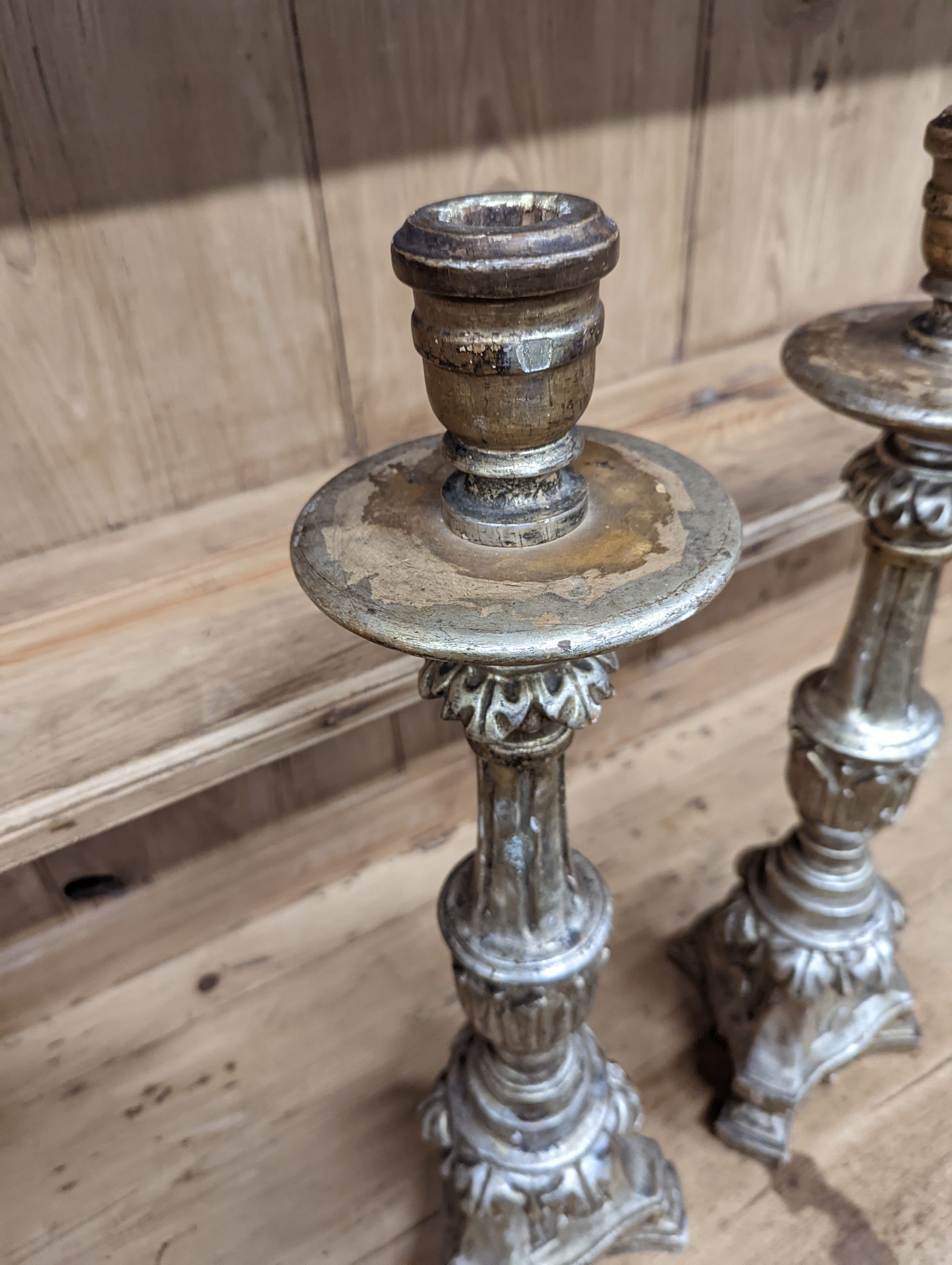 A pair of 18th century style carved silvered wood candlesticks, height 58cm